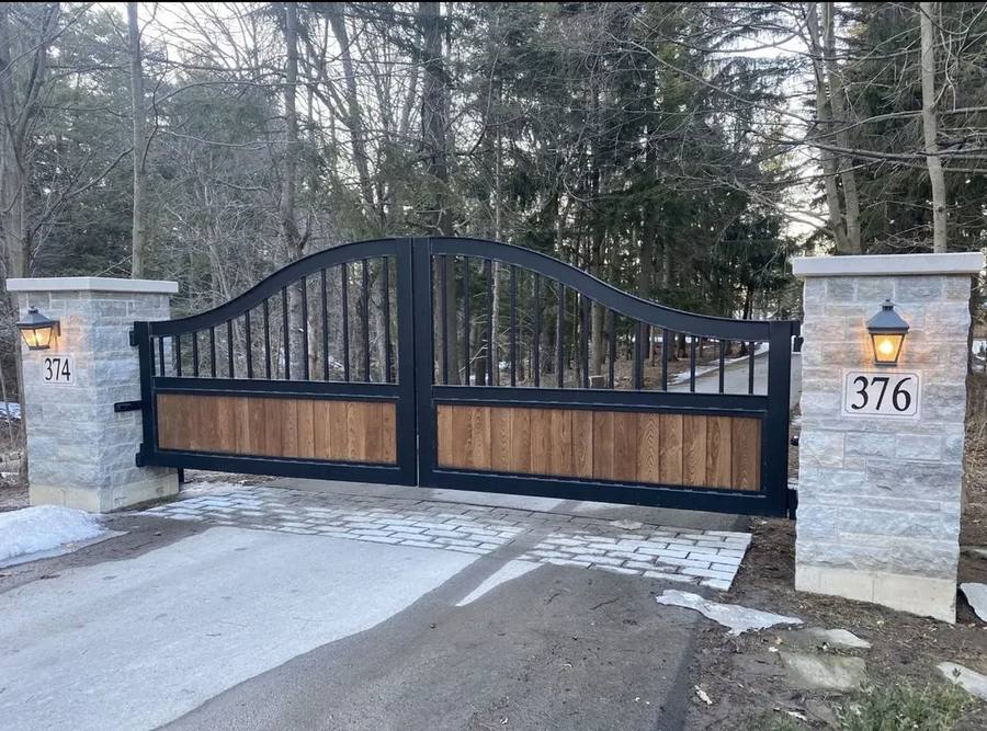 Arched driveway gate with wood and steel combination