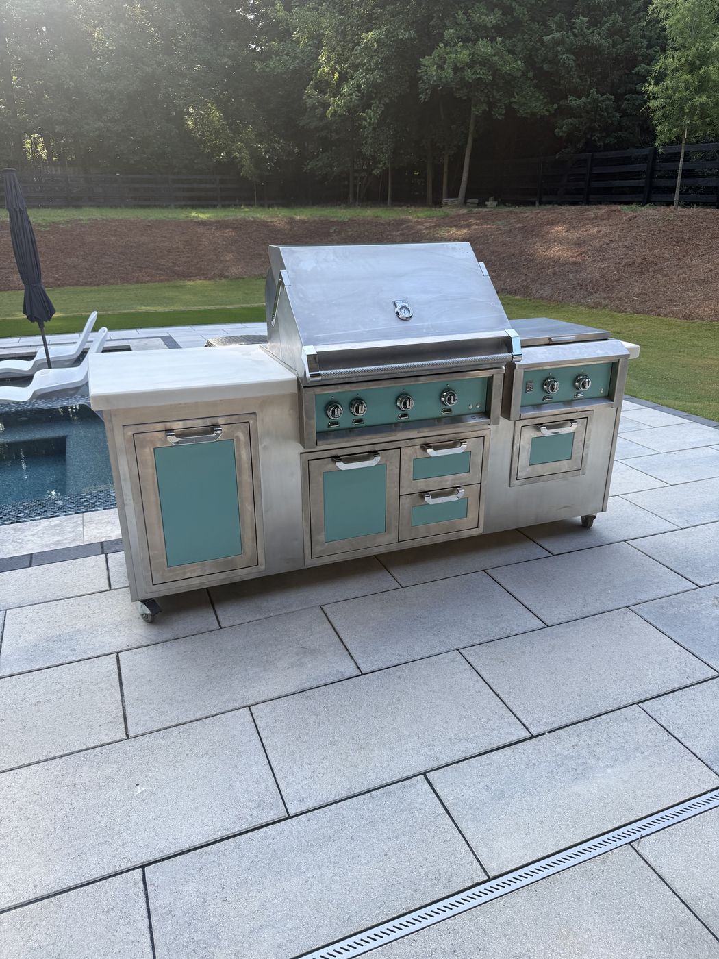 Custom stainless steel outdoor kitchen with teal accent panels - KeithCo custom fabrication Georgia